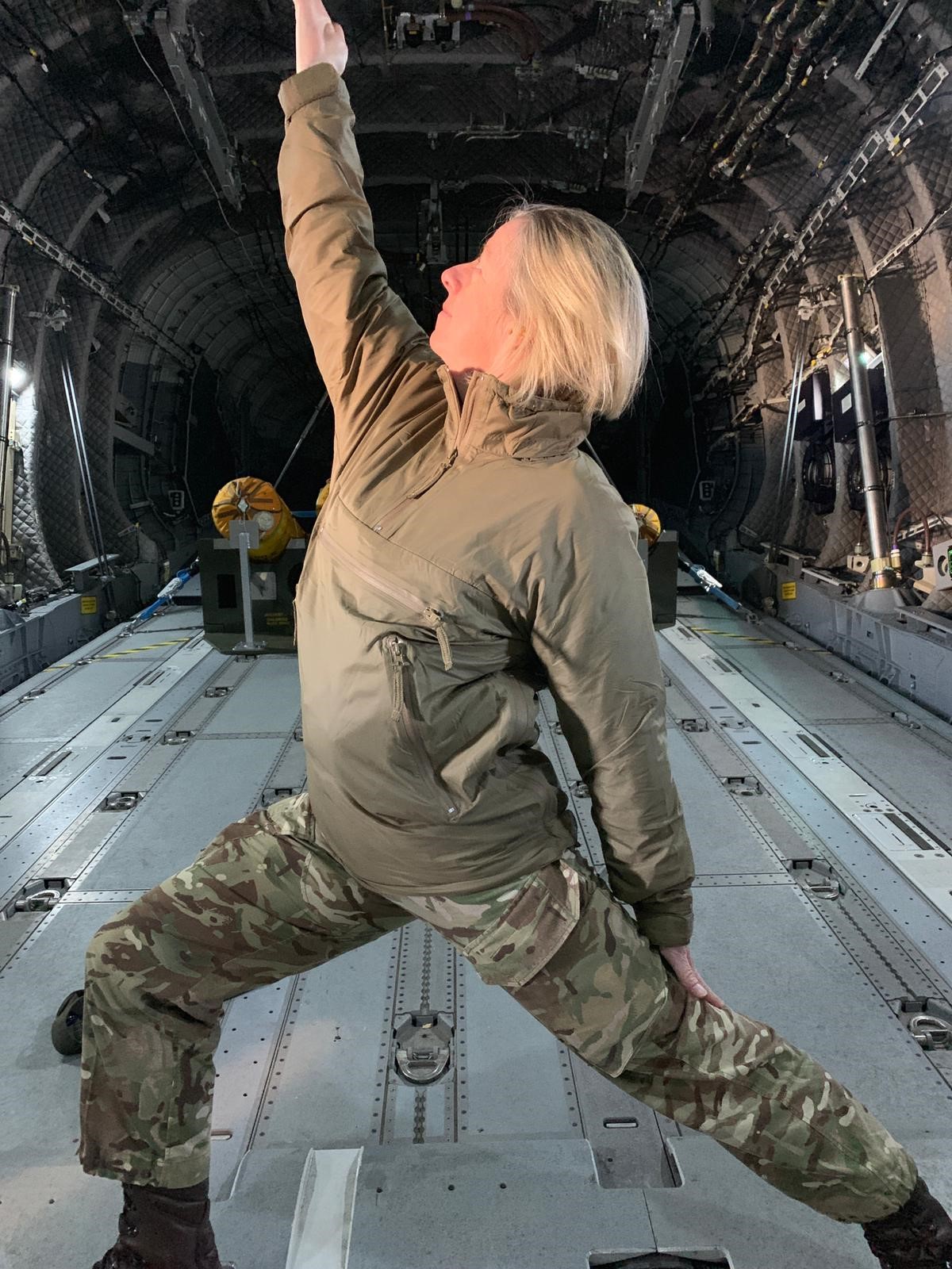 Personnel doing yoga in aircraft.